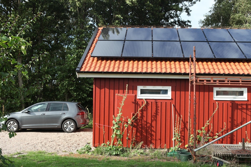 Ola bredvid sitt batteri som lagrar överskottet av solel.